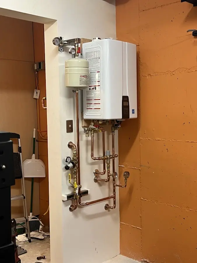 Plumbing technician inspecting water heater connections in Rio Rico